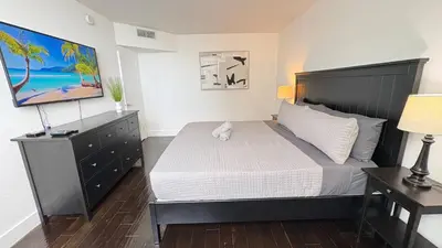 a bedroom with a large bed and a dresser and a bed sidx sidx sidx at Beachfront 2BR at The Tides | EPIC Stay in Hollywood