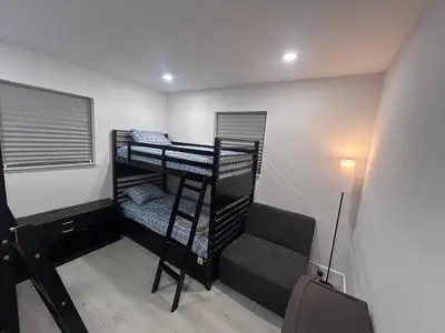 a room with three bunk beds and a suitcase at Place to stay in Hallandale Beach