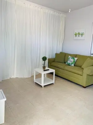a living room with a green couch and a table at Zen Garden Studio in Hollywood