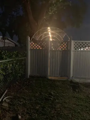 a white fence with a gate in a yard at night at Zen Garden Studio in Hollywood