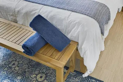 a bed with two blue pillows sitting on a bench at Positano Ville I Waterfront and Grill I 10 min Beach in Fort Lauderdale