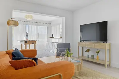 a living room with a couch and a tv at Positano Ville I Waterfront and Grill I 10 min Beach in Fort Lauderdale