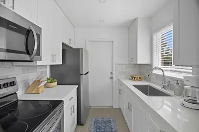 a white kitchen with a sink and a microwave at Positano Ville I Waterfront and Grill I 10 min Beach in Fort Lauderdale