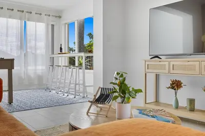 a living room with a tv and a table at Positano Ville I Waterfront and Grill I 10 min Beach in Fort Lauderdale