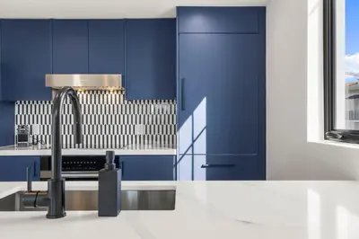 a kitchen with blue cabinets and a sink at The Avenue Hotel Coral Gables in Miami