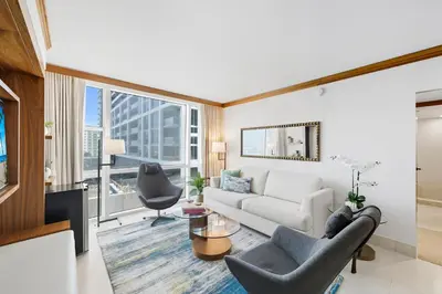 a living room with a white couch and a large window at Skyline View Private Residence at Carillon Resort - 705 in Miami Beach