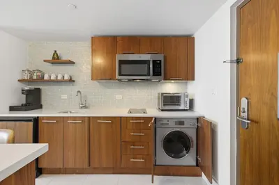 a kitchen with a washing machine and a microwave at Skyline View Private Residence at Carillon Resort - 705 in Miami Beach