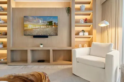 a living room with a white chair and a tv at Oceanview Private Residence at 1 Hotel and Homes - 1202 in Miami Beach