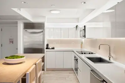 a kitchen with white cabinets and a wooden counter top at Oceanview Private Residence at 1 Hotel and Homes - 1202 in Miami Beach