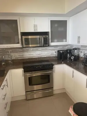 a kitchen with a stainless steel oven and microwave at Luxurious 2BD Condo with Direct Ocean Views & Resort Pool in Sunny Isles in Sunny Isles Beach