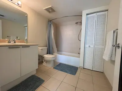 a bathroom with a tub and a toilet and a sink at Luxurious 2BD Condo with Direct Ocean Views & Resort Pool in Sunny Isles in Sunny Isles Beach