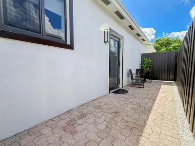 a patio of a house with a fence at Luxury Suite Studio with Kitchen & Spa Shower in Miramar