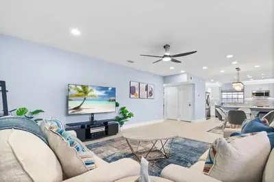 a living room with a couch and a flat screen tv at Las Olas & Beachside getaway with pool in Fort Lauderdale