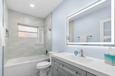 a bathroom with a sink and a toilet and a mirror at Las Olas & Beachside getaway with pool in Fort Lauderdale