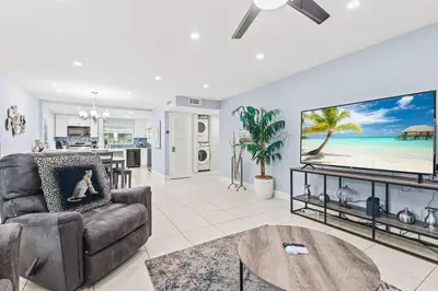 a living room with a couch and a large screen tv at Beach Pool & Las Olas Getaway Fort Lauderdale in Fort Lauderdale