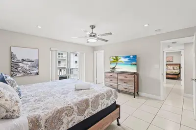 a bedroom with a bed and a dresser and a television at Beach Pool & Las Olas Getaway Fort Lauderdale in Fort Lauderdale