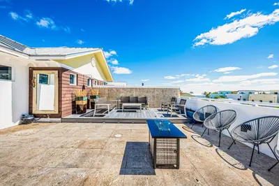 a patio with chairs and a table on top of a building at Walk to Hollywood Beach Luxury Family Getaway! in Hollywood