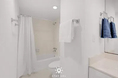a white bathroom with a toilet and a shower at Modern Hollywood Beach Escape - City Views in Hollywood