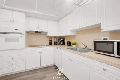 a white kitchen with a sink and a microwave at Modern Hollywood Beach Escape - City Views in Hollywood