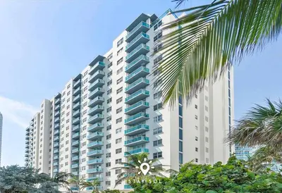 a large white building with palm trees in front of it at Modern Hollywood Beach Escape - City Views in Hollywood