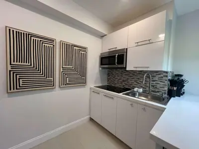 a kitchen with white cabinets and a sink at The Modern Oasis Queen Studio with Kitchen in Fort Lauderdale