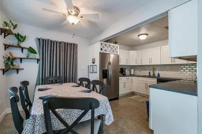 a kitchen with a table with chairs and a refrigerator at Jungle Fortress in Fort Lauderdale