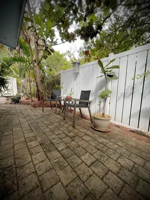 a patio with a table and chairs and a fence at Jungle Fortress in Fort Lauderdale