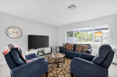 a living room with two blue couches and a tv at 2BR Home Near Wilton Manors & Downtown in Fort Lauderdale
