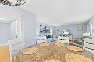 a living room with a large wooden table and chairs at Beachside Las Olas Getaway Oasis with Pool in Fort Lauderdale