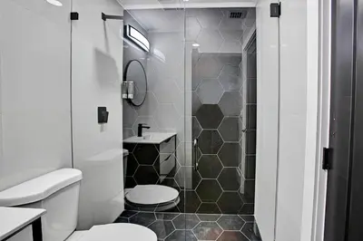 a bathroom with a shower with a toilet and a sink at Coral Lane by Rove Travel - Home with Pool & BBQ in Fort Lauderdale