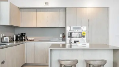 a kitchen with white cabinets and a counter with stools at Hyde House in Hollywood