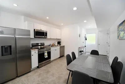 a kitchen with a table and a stainless steel refrigerator at Coastal Collection in Fort Lauderdale