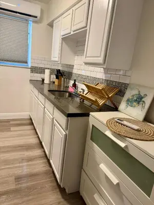 a kitchen with white cabinets and a sink at Sunny Miami Beach Getaway , Steps from the Ocean! in Miami Beach