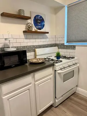 a kitchen with a white stove and a microwave at Sunny Miami Beach Getaway , Steps from the Ocean! in Miami Beach