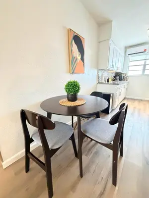 a dining room table with two chairs and a plant on it at Sunny Miami Beach Getaway , Steps from the Ocean! in Miami Beach