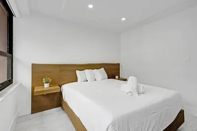 a white bedroom with a large bed with white sheets at Stylish 3BR Retreat Steps from the Beach with Resort Amenities 1508 in Miami Beach
