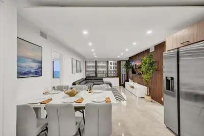 a kitchen and dining room with a table and chairs at Modern 3BR Ocean view Condo with Pools, Gym and Sauna 1407 in Miami Beach