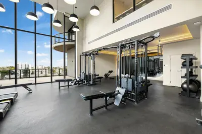 a gym with several tread machines and large windows at 72 Park Condo - City Views & Prime Location in Miami Beach