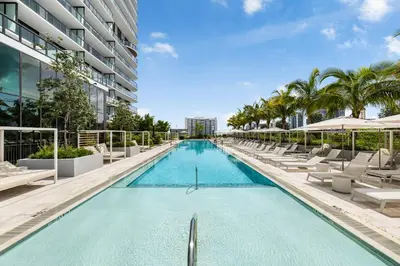 a swimming pool with lounge chairs and a building at 72 Park Condo - City Views & Prime Location in Miami Beach