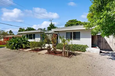 a white house with plants in a driveway at Casa Sol B in Fort Lauderdale
