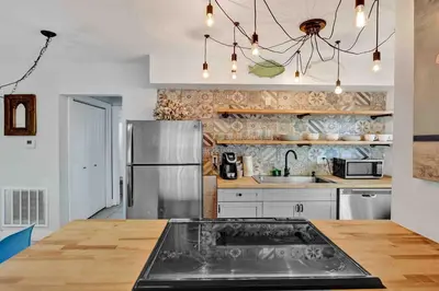 a kitchen with a stainless steel refrigerator and a wooden table at Casa Sol B in Fort Lauderdale