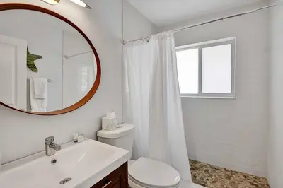 a bathroom with a toilet and a sink and a mirror at Casa Sol B in Fort Lauderdale