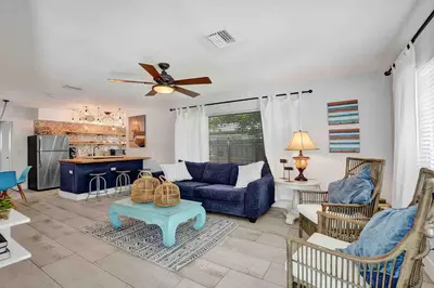 a living room with a blue couch and a ceiling fan at Casa Sol B in Fort Lauderdale