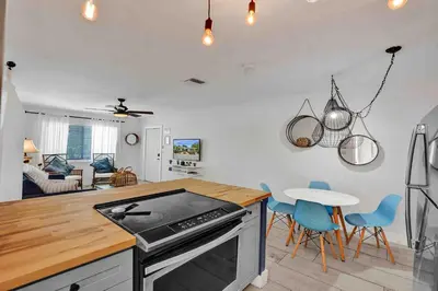 a kitchen and living room with a stove and chairs at Casa Sol B in Fort Lauderdale