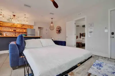 a bedroom with a large bed and blue chairs at Casa Sol in Fort Lauderdale
