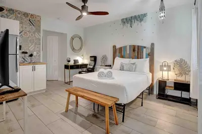 a bedroom with a large white bed and a desk at Casa Sol A in Fort Lauderdale
