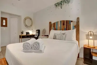 a bedroom with a large white bed with towels on it at Casa Sol A in Fort Lauderdale