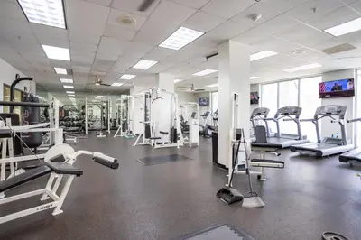 a gym with several treadmills and machines at 1-Bedroom Apartment with Ocean View and Balcony near Sunny Isles Beach in Sunny Isles Beach