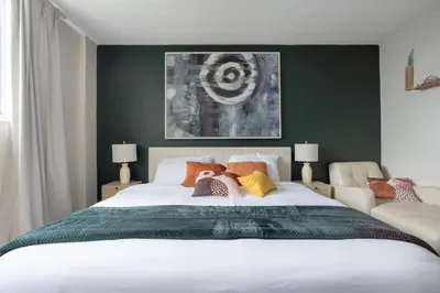 a bedroom with a large white bed with green walls at 1-Bedroom Apartment with Ocean View and Balcony near Sunny Isles Beach in Sunny Isles Beach