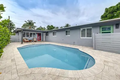a swimming pool in front of a house at Walkable Island City Oasis with Private Heated Pool! in Fort Lauderdale